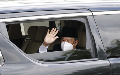 Embattled Malaysian Prime Minister Muhyiddin Yassin waves from a car while entering the National Palace to meet with the King in Kuala Lumpur, Malaysia, Aug. 16, 2021 (AP Photo/FL Wong)