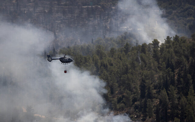 An Israeli helicopter drops water while battling the second day of wildfires near Shoresh, on the outskirts of Jerusalem, Aug. 16, 2021 (AP Photo/Maya Alleruzzo)
