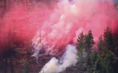 Smoke and red fire retardant sprayed by Israeli firefighting aircraft mingles on a hillside on the third day of wildfires in the Jerusalem mountains, August 17, 2021. (AP Photo/Ariel Schalit)