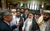 In this Tuesday, May 28, 2019 file photo, Russian presidential envoy to Afghanistan Zamir Kabulov, left, speaks to Mullah Abdul Ghani Baradar, the Taliban group's top political leader, third left, Sher Mohammad Abbas Stanikzai, the Taliban's chief negotiator, third right, and other members of the Taliban delegation prior to their talks in Moscow, Russia.  (AP Photo/Alexander Zemlianichenko, File)