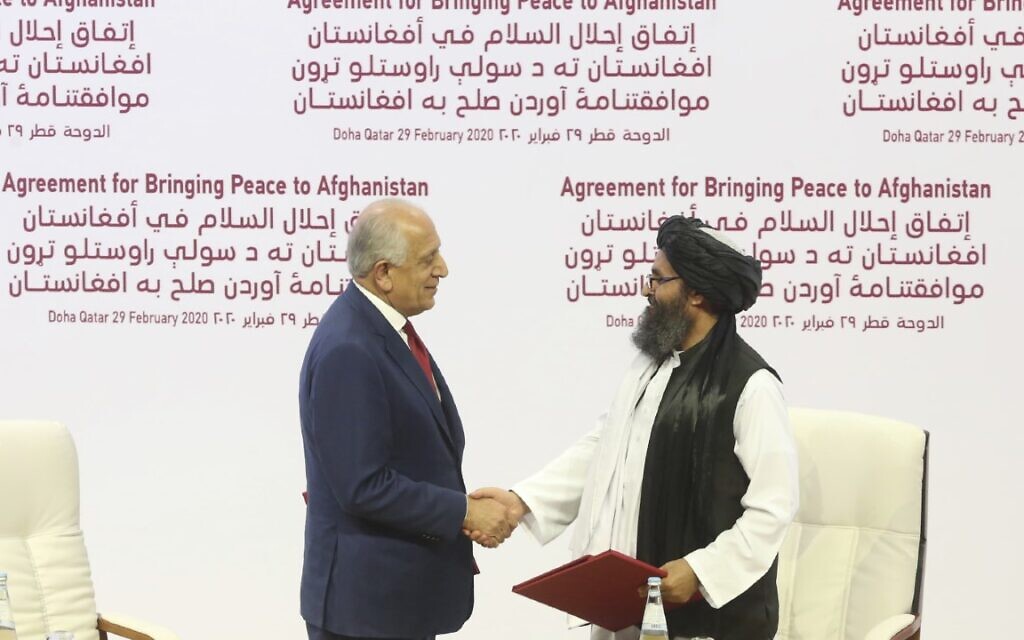 In this Feb. 29, 2020 file photo, US peace envoy Zalmay Khalilzad, left, and Mullah Abdul Ghani Baradar, the Taliban group's top political leader, shake hands after signing a peace agreement between Taliban and US officials in Doha, Qatar. (AP Photo/Hussein Sayed, File) In this Feb. 29, 2020 file photo, US peace envoy Zalmay Khalilzad, left, and Mullah Abdul Ghani Baradar, the Taliban group's top political leader, shake hands after signing a peace agreement between Taliban and US officials in Doha, Qatar. (AP Photo/Hussein Sayed, File)