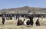 Hundreds of people gather near a US Air Force C-17 transport plane at the perimeter of the international airport in Kabul, Afghanistan, on Monday, August 16, 2021. (AP Photo/Shekib Rahmani)