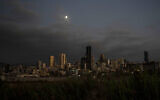 The moon rises over the capital city of Beirut as it remains in darkness during a power outage, Lebanon, August 19, 2021.(AP/ Hassan Ammar)