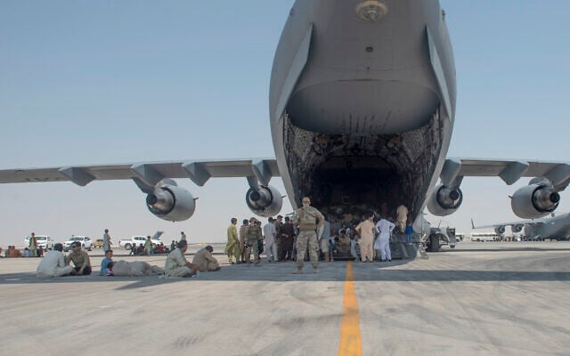 In this photo provided by the U.S. Air Force, evacuees wait under the wing of C-17 Globemaster lll after arriving in an undisclosed location in the Middle East region on Friday, Aug. 20, 2021, after being evacuated onboard a military aircraft from Hamid Karzai International Airport in Kabul, Afghanistan, as part of Operation Allies Refuge. (Airman 1st Class Kylie Barrow, U.S. Air Force via AP) In this photo provided by the U.S. Air Force, evacuees wait under the wing of C-17 Globemaster lll after arriving in an undisclosed location in the Middle East region on Friday, Aug. 20, 2021, after being evacuated onboard a military aircraft from Hamid Karzai International Airport in Kabul, Afghanistan, as part of Operation Allies Refuge. (Airman 1st Class Kylie Barrow, U.S. Air Force via AP)