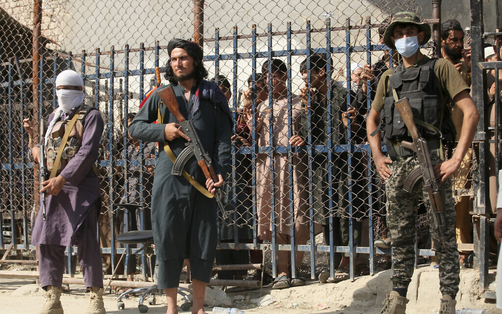A Pakistani paramilitary soldier, right, and Taliban fighters stand guard on their respective sides at a border crossing point between Pakistan and Afghanistan, in Torkham, in Khyber district, Pakistan, August 21, 2021. (AP Photo/Muhammad Sajjad) A Pakistani paramilitary soldier, right, and Taliban fighters stand guard on their respective sides at a border crossing point between Pakistan and Afghanistan, in Torkham, in Khyber district, Pakistan, August 21, 2021. (AP Photo/Muhammad Sajjad)