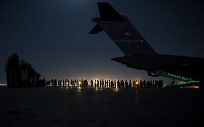 In this image provided by the US Air Force, US Air Force aircrew, assigned to the 816th Expeditionary Airlift Squadron, prepare to load qualified evacuees aboard a US Air Force C-17 Globemaster III aircraft in support of the Afghanistan evacuation at Hamid Karzai International Airport, Kabul, Afghanistan, August 21, 2021. (Senior Airman Taylor Crul/U.S. Air Force via AP)