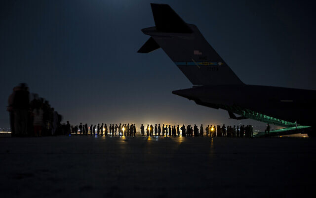 In this image provided by the US Air Force, US Air Force aircrew, assigned to the 816th Expeditionary Airlift Squadron, prepare to load qualified evacuees aboard a US Air Force C-17 Globemaster III aircraft in support of the Afghanistan evacuation at Hamid Karzai International Airport, Kabul, Afghanistan, August 21, 2021. (Senior Airman Taylor Crul/U.S. Air Force via AP) In this image provided by the US Air Force, US Air Force aircrew, assigned to the 816th Expeditionary Airlift Squadron, prepare to load qualified evacuees aboard a US Air Force C-17 Globemaster III aircraft in support of the Afghanistan evacuation at Hamid Karzai International Airport, Kabul, Afghanistan, August 21, 2021. (Senior Airman Taylor Crul/U.S. Air Force via AP)