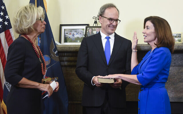New York Chief Judge Janet DiFiore, left, swears in Kathy Hochul, right, as the first woman to be New York's governor while her husband, Bill Hochul, holds a bible during a swearing-in ceremony in the Red Room at the state Capitol, early Tuesday, Aug. 24, 2021, in Albany, N.Y. (AP Photo/Hans Pennink, Pool) New York Chief Judge Janet DiFiore, left, swears in Kathy Hochul, right, as the first woman to be New York's governor while her husband, Bill Hochul, holds a bible during a swearing-in ceremony in the Red Room at the state Capitol, early Tuesday, Aug. 24, 2021, in Albany, N.Y. (AP Photo/Hans Pennink, Pool)