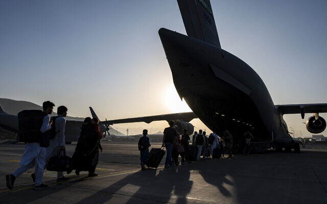 In this image provided by the U.S. Air Force, US Air Force airmen guide evacuees aboard a US Air Force C-17 Globemaster III at Hamid Karzai International Airport in Kabul, Afghanistan, Tuesday, Aug. 24, 2021. (Senior Airman Taylor Crul/U.S. Air Force via AP) In this image provided by the U.S. Air Force, US Air Force airmen guide evacuees aboard a US Air Force C-17 Globemaster III at Hamid Karzai International Airport in Kabul, Afghanistan, Tuesday, Aug. 24, 2021. (Senior Airman Taylor Crul/U.S. Air Force via AP)