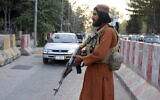 A Taliban fighter stands guard at a checkpoint, in Kabul, Afghanistan, on August 25, 2021. (AP Photo/Khwaja Tawfiq Sediqi)