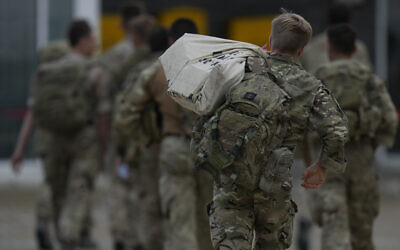 Members of the British armed forces 16 Air Assault Brigade walk to the air terminal after disembarking a RAF Voyager aircraft at Brize Norton, England, as they return from helping in operations to evacuate people from Kabul airport in Afghanistan, on August 28, 2021. (AP Photo/Alastair Grant, Pool)