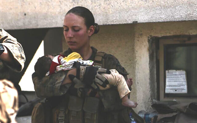 This undated photo provided by the US Department of Defense twitter page posted August 20, 2021 shows Sgt. Nicole Gee holding a baby at Hamid Karzai International Airport in Kabul, Afghanistan. (US Department of Defense via AP) This undated photo provided by the US Department of Defense twitter page posted August 20, 2021 shows Sgt. Nicole Gee holding a baby at Hamid Karzai International Airport in Kabul, Afghanistan. (US Department of Defense via AP)