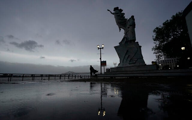 A man walks along the Mississippi River near the French Quarter as the sun rises and the early effects of Hurricane Ida are felt, Sunday, Aug. 29, 2021, in New Orleans, La. (AP Photo/Eric Gay) A man walks along the Mississippi River near the French Quarter as the sun rises and the early effects of Hurricane Ida are felt, Sunday, Aug. 29, 2021, in New Orleans, La. (AP Photo/Eric Gay)