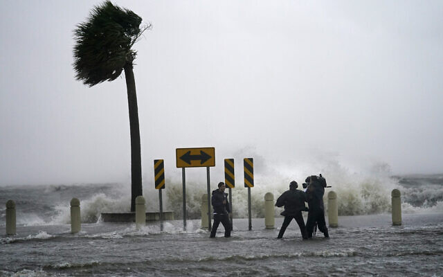 A news crew reports on the edge of Lake Pontchartrain ahead of approaching Hurricane Ida in New Orleans, Sunday, Aug. 29, 2021. (AP Photo/Gerald Herbert)