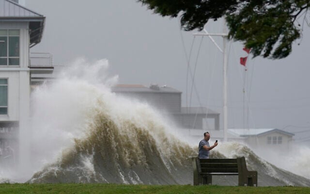 A man takes pictures of high waves along the shore of Lake Pontchartrain as Hurricane Ida nears, Sunday, Aug. 29, 2021, in New Orleans. (AP Photo/Gerald Herbert) A man takes pictures of high waves along the shore of Lake Pontchartrain as Hurricane Ida nears, Sunday, Aug. 29, 2021, in New Orleans. (AP Photo/Gerald Herbert)