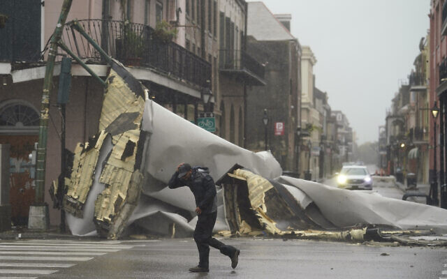 A man passes by a section of roof that was blown off of a building in the French Quarter by Hurricane Ida winds, Sunday, Aug. 29, 2021, in New Orleans. (AP Photo/Eric Gay) A man passes by a section of roof that was blown off of a building in the French Quarter by Hurricane Ida winds, Sunday, Aug. 29, 2021, in New Orleans. (AP Photo/Eric Gay)