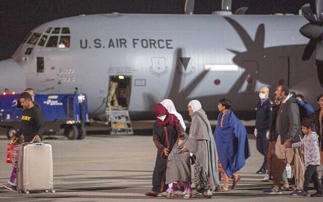 Families evacuated from Kabul, Afghanistan, walks past an US air force airplane that flew them at Kosovo's capital Pristina International Airport on August 29, 2021. (AP Photo/Visar Kryeziu) Families evacuated from Kabul, Afghanistan, walks past an US air force airplane that flew them at Kosovo's capital Pristina International Airport on August 29, 2021. (AP Photo/Visar Kryeziu)
