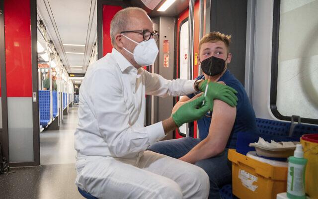 Christian Gravert, left, chief medical officer of the Deutsche Bahn, vaccinates a man with the Johnson & Johnson vaccine in a special train of the public transport S-Bahn, in which vaccination against COVID-19 are offered, in Berlin, Germany, August 30, 2021. (Christophe Gateau/dpa via AP) Christian Gravert, left, chief medical officer of the Deutsche Bahn, vaccinates a man with the Johnson & Johnson vaccine in a special train of the public transport S-Bahn, in which vaccination against COVID-19 are offered, in Berlin, Germany, August 30, 2021. (Christophe Gateau/dpa via AP)