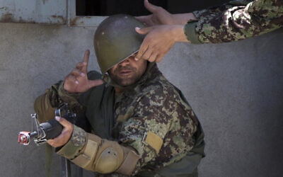 A military instructor adjusts the helmet of an Afghan Army soldier during a house-to-house search at a training facility in the outskirts of Kabul, Afghanistan, May 8, 2013. (Anja Niedringhaus/AP) A military instructor adjusts the helmet of an Afghan Army soldier during a house-to-house search at a training facility in the outskirts of Kabul, Afghanistan, May 8, 2013. (Anja Niedringhaus/AP)