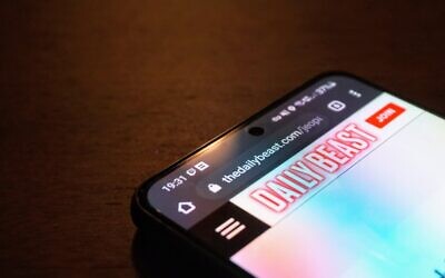 The Daily Beast website is seen on a smartphone, on August 17, 2021. (The Times of Israel)