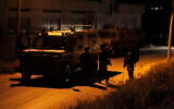 Illustrative: IDF soldiers stand guard during a search in the West Bank village of Yatta, on June 15, 2016. (Wisam Hashlamoun/Flash90)