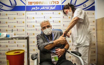Salman Zarka receives a Covid-19 vaccine at the Ziv Medical Center in the northern Israeli city of Safed, on December 21, 2020 (David Cohen/Flash90)