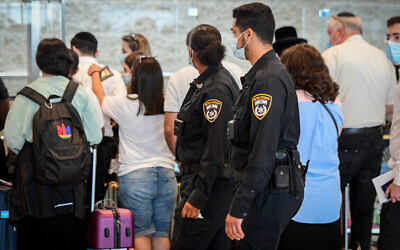 Illustrative -- Police officers enforce COVID-19 regulations at Ben Gurion International Airport, on July 19, 2021. (Avshalom Sassoni/Flash90)