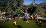 People enjoy a hot summer day at the Ein Lavan Spring in the Jerusalem Mountains, July 28, 2021. (Yonatan Sindel/Flash90)