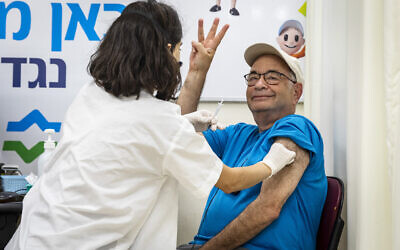 An Israeli man receives a third dose of the COVID-19 vaccine at a Clalit health care maintenance organization in Jerusalem, on August 1, 2021. (Olivier Fitoussi/Flash90)