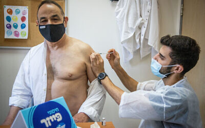 An Israeli receives a coronavirus booster shot at a Maccabi Healthcare Services vaccination center, on August 1, 2021. (Yonatan Sindel/Flash90)