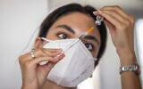 A Magen David Adom worker prepares a COVID-19 vaccine in Jerusalem, on August 4, 2021. (Yonatan Sindel/Flash90)