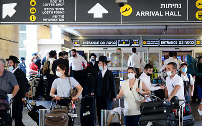 Travelers are seen wearing face masks at Ben Gurion International Airport on August 5, 2021. (Avshalom Sassoni/ FLASH90)