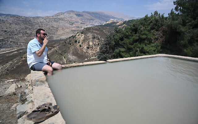 A man sits in a water spring in the Golan Heights, northern Israel, during the summer vacation, on August 6, 2021. (Michael Giladi/Flash90) A man sits in a water spring in the Golan Heights, northern Israel, during the summer vacation, on August 6, 2021. (Michael Giladi/Flash90)