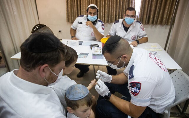 A Magen David Adom worker takes blood for a serological test for COVID-19 from a child in the ultra-Orthodox town of Kiryat Ye'arim (Telz-Stone), outside Jerusalem, on August 9, 2021. (Yonatan Sindel/Flash90) A Magen David Adom worker takes blood for a serological test for COVID-19 from a child in the ultra-Orthodox town of Kiryat Ye'arim (Telz-Stone), outside Jerusalem, on August 9, 2021. (Yonatan Sindel/Flash90)