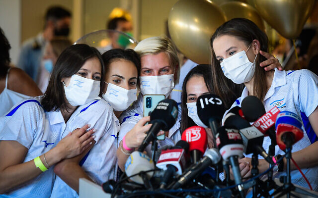 Olympic Gold medalist Linoy Ashram (2L) is greeted by press, family and friends as she arrives at Ben Gurion Airport after winning the Gold medal in the rhythmic gymnast at the Olympic Games in Japan, August 11, 2021. (Avshalom Sassoni/Flash90) Olympic Gold medalist Linoy Ashram (2L) is greeted by press, family and friends as she arrives at Ben Gurion Airport after winning the Gold medal in the rhythmic gymnast at the Olympic Games in Japan, August 11, 2021. (Avshalom Sassoni/Flash90)