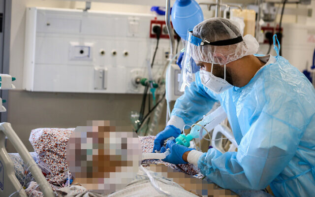 Hospital staff wearing safety gear as they work in the coronavirus ward of Ziv Medical Center in the northern city of Safed on August 11, 2021. (David Cohen/Flash90) Hospital staff wearing safety gear as they work in the coronavirus ward of Ziv Medical Center in the northern city of Safed on August 11, 2021. (David Cohen/Flash90)