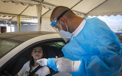 Magen David Adom staff test Israelis for COVID-19 at a Drive-In rapid antigen test complex in Glilot, on August 12, 2021. (Olivier Fitoussi/Flash90)