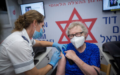 A woman receives a COVID-19 vaccine shot at a mobile Magen David Adom center on Dizengoff Square in Tel Aviv, on August 14, 2021. (Miriam Alster/Flash90)