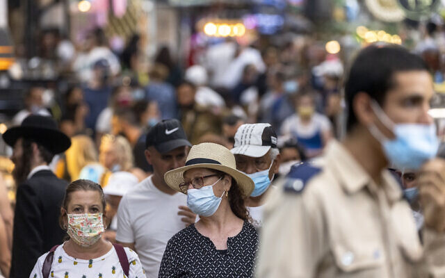 People, some with face masks, shop at the Mahane Yehuda market in Jerusalem on August 15, 2021. (Olivier Fitoussi/Flash90)