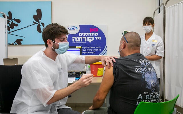 People receive their COVID-19 vaccine at a vaccination center in Modiin on August 15, 2021. (Yossi Aloni/Flash90) People receive their COVID-19 vaccine at a vaccination center in Modiin on August 15, 2021. (Yossi Aloni/Flash90)