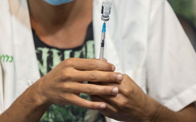 A health worker prepares a COVID-19 vaccine at a temporary Clalit health care center in Jerusalem, August 15, 2021. (Yonatan Sindel/Flash90) A health worker prepares a COVID-19 vaccine at a temporary Clalit health care center in Jerusalem, August 15, 2021. (Yonatan Sindel/Flash90)