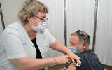 A man receives a third dose of the coronavirus at a health center in Katzrin, on the Golan Heights, August 16, 2021. (Michael Giladi/Flash90)