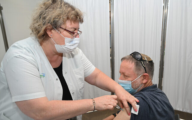 A man receives a third dose of the coronavirus at a health center in Katzrin, on the Golan Heights, August 16, 2021. (Michael Giladi/Flash90) A man receives a third dose of the coronavirus at a health center in Katzrin, on the Golan Heights, August 16, 2021. (Michael Giladi/Flash90)