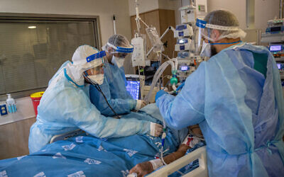 Hadassah Ein Kerem team members wearing safety gear as they work in the hospital's coronavirus ward, on August 25, 2021. (Yonatan Sindel/Flash90)