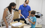 Parents and children from the "Cramim" school receive a COVID-19 home kit test ahead of the opening of the new school year, in Jerusalem, on August 30, 2021. (Olivier Fitoussi/Flash90)