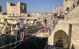 Walking across a hanging bridge in the Tower of David Museum ropes course, open in August 2021. (Jessica Steinberg/Times of Israel)