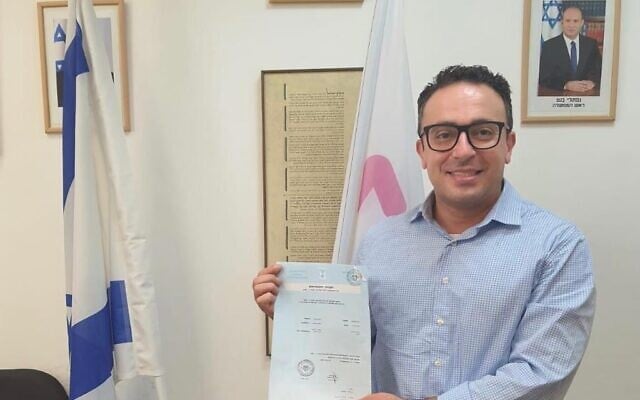 Kuwaiti-born Mark Halawa holding his new Israeli citizenship documentation, August 2021. (courtesy)