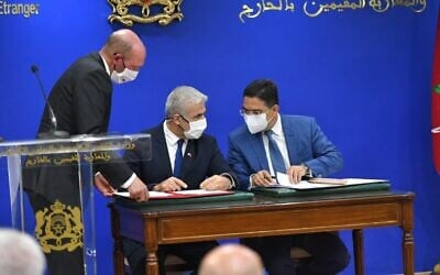 Foreign Minister Yair Lapid (left) and Moroccan Foreign Minister Nasser Bourita (right) sign three framework agreements in Rabat, on August 11, 2021. (Shlomi Amsalem/GPO)