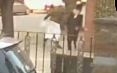 A man in traditional Muslim garb is seen punching an ultra-Orthodox man in the street, in the heavily-Jewish neighborhood of Stamford Hill. (Screenshot/Twitter)