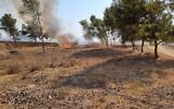 Firefighters try to extinguish a blaze in southern Israel that was sparked by a ballon-borne incendiary device launched by Palestinians in the Gaza Strip, on August 6, 2021. (Moshe Baruchi/KKL-JNF)